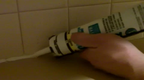 Fix it guy caulking kitchen countertop and tile wall Stock Footage 44789105