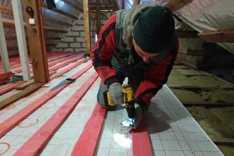 Fixation and warming of the attic, fixation of the waterproofing film on the  Fotos Stock