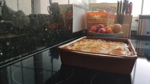 Fixed close-up, placing traditional Italian lasagna on the counter. Home cook Stock Footage