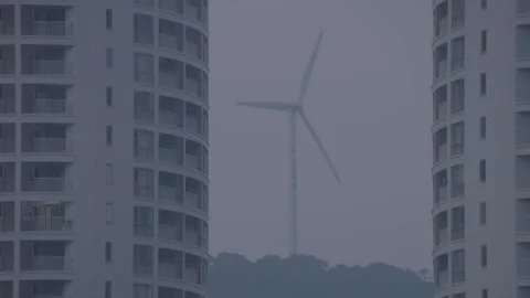 Fixed filming of wind power behind residential buildings. Stock Footage 249243322