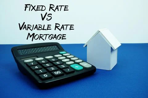 Fixed Rate Vs Variable Rate Mortgage text with White house model with calcu.. Fotos de archivo