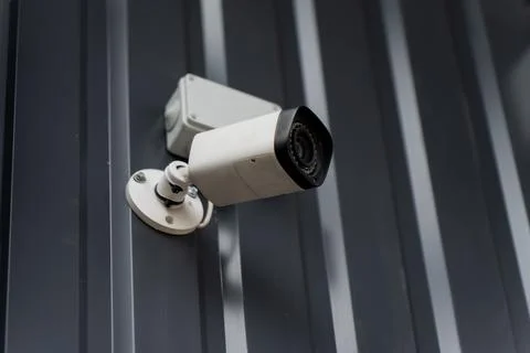 Fixed security camera attached to profiled steel siding Stock Photos