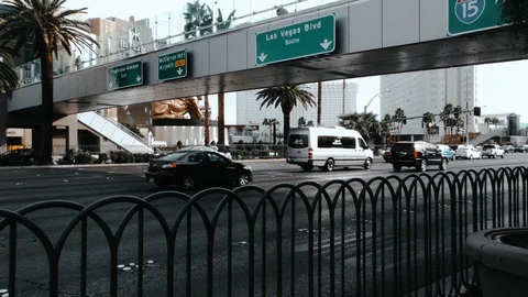 Fixed shot of daytime traffic passing under a bridge on the Las Vegas strip Stock Footage 106621639