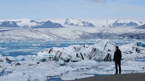 Fixed shot of a man looking at icebergs in Jökulsárlón, in Iceland Stock Footage 71292003