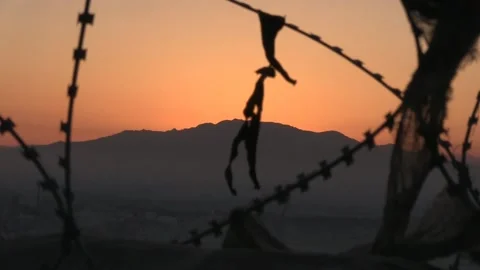 Fixed shot of the sun setting behind a mountain above Kandahar in Afghanistan. Stock Footage 189830647
