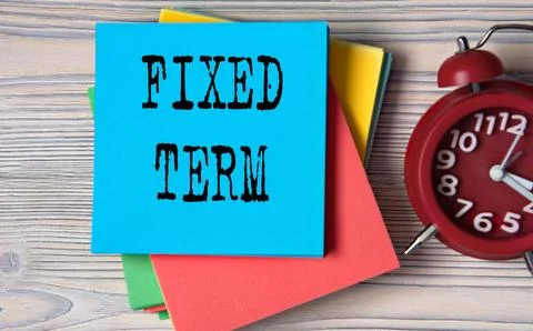 FIXED TERM - words on a note paper on the background of a red alarm clock Stock Photos