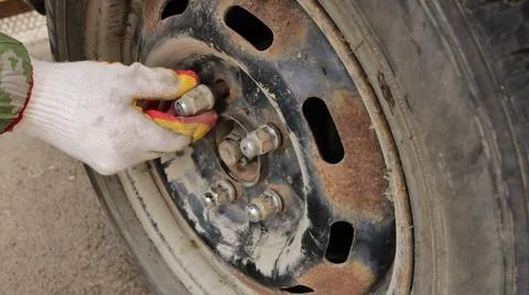 Fixing bolts when changing rubber on an old rusty car rim Stock Photos
