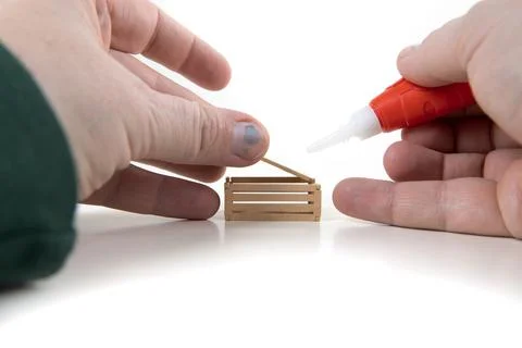Fixing a broken toy apple box applying glue to the base Stock Photos