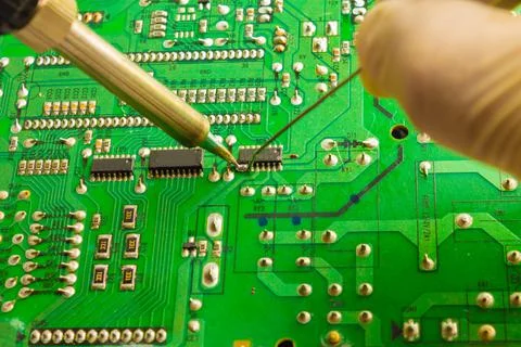 Fixing the chip with a soldering iron using tin solder Stock Photos