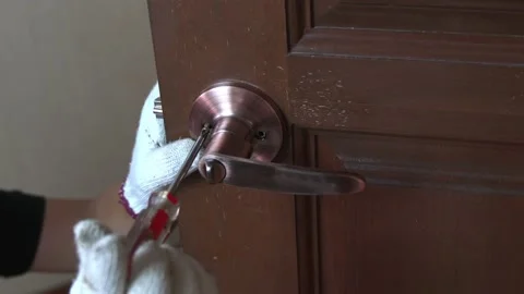 Fixing door knob, close up view of man using a screwdriver. Stock Footage 185393738