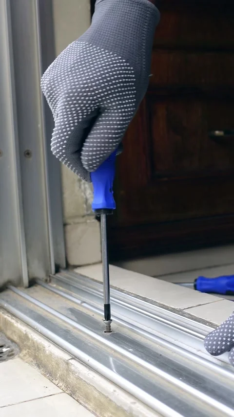 Fixing a door track with a screwdriver at home Stock Footage 339517841