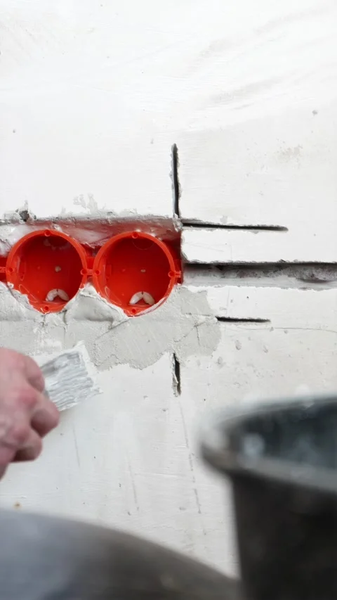 Fixing electrical socket box into wall with plaster putty vertical Stock Footage 339298263