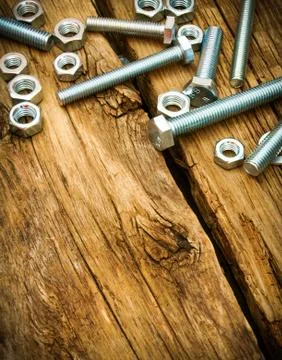 Fixing elements (nuts, screws) on wooden background. Foto stock