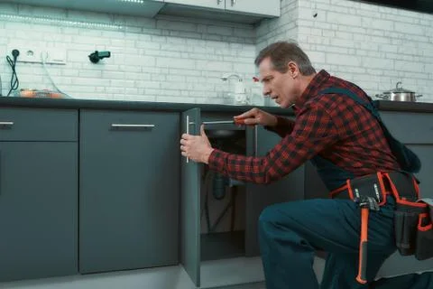 Fixing everything. Man solves household problems. Mature man wearing tool kit 写真素材