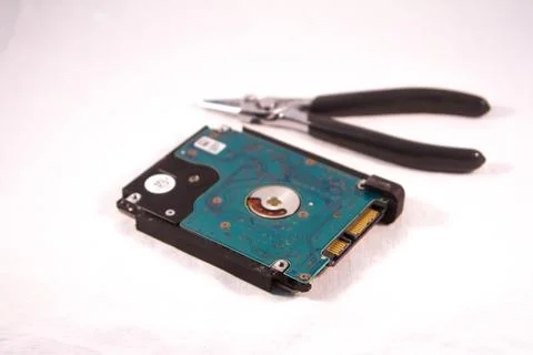 Fixing a hard disk drive with one hand with gloves and a special tweezers Stock Photos