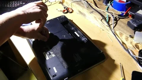 Fixing a laptop by opening the back cover and removing screws to replace the har Stock Footage 328416683