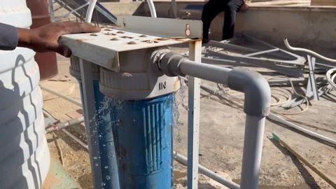 Fixing a Leaking Water Filter Housing on a Rooftop Stock Footage 345611670