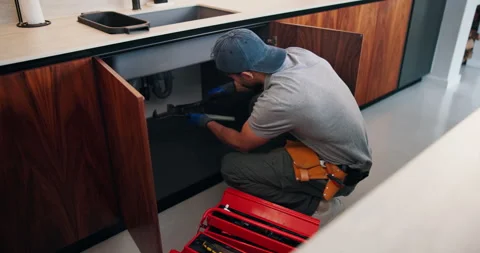 Fixing, pipe and man with tools in kitchen, drainage system maintenance and Stock Footage 335104210