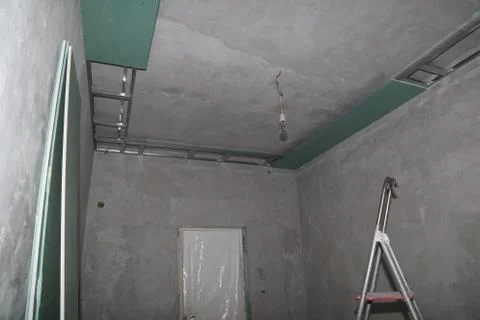 Fixing plaster boards at the ceiling during construction Foto stock
