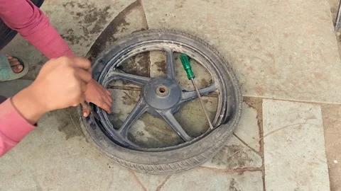Fixing puncture motorcycle tyre installing tube repair roadside maintenance Stock Footage 334195456