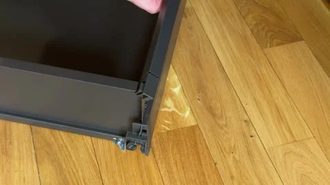 Fixing rear end of drawer rail mechanism to wooden panel close up Stockbeeldmateriaal 333788876