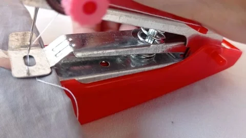 Fixing a red tiny sewing tool Stock Footage 145623758