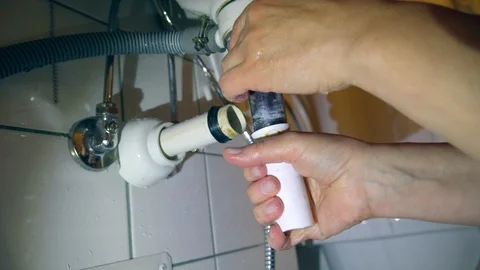 Fixing the silver pipe under the sink in the bathroom Stock Footage 96420952