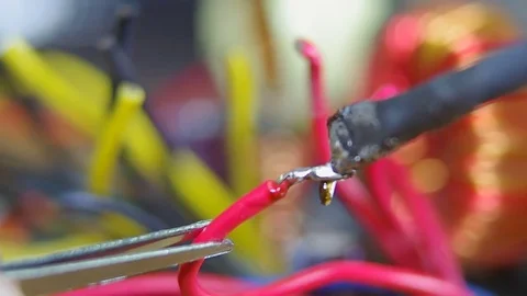 Fixing with the soldering iron of two red wires Stock Footage 81787115