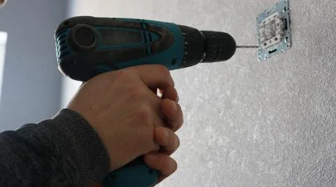 Fixing a switch to the wall with a screwdriver Stock Photos