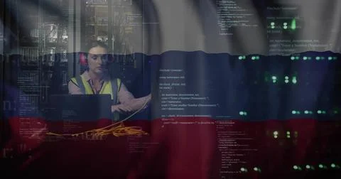 Fixing tech hi-vis red muffs patching yellow LAN cables using laptop near server 写真素材