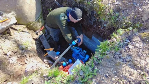 Fixing a water pump in a residential area in the afternoon 스톡 동영상 337441012
