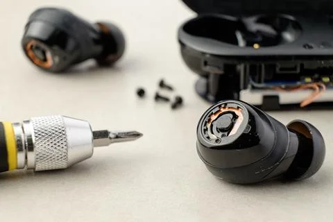 Fixing wireless earbuds with precision tools on a smooth surface Stock Photos
