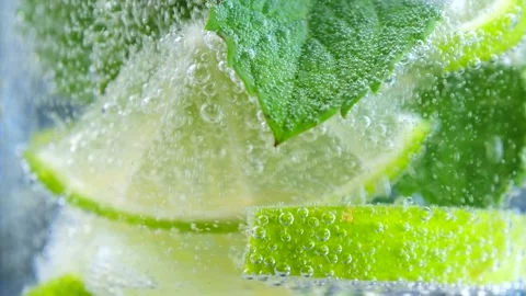 Fizzing of sparkling water with lime and mint in glass Stock Footage 282643987