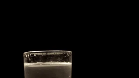 Fizzy Carbonated Liquid Bubbling Inside Glass On Solid Black Background Video stock 330300815