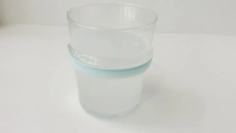 Fizzy effervescent tablet dissolving in a glass of water isolated on a whit.. Vídeos de archivo 335141538