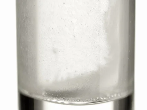 Fizzy pill aspirin tablet dropping to glass of water 4k video. Extreme close up Stock Footage 83931969
