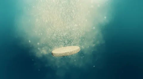 Fizzy pill dissolves in the water - loop Video stock 31562764