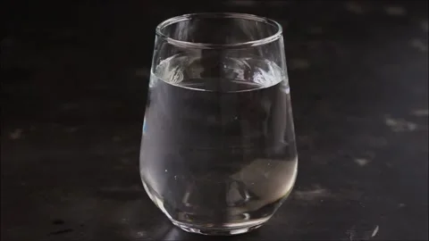A fizzy vitamin C tablet falls into a glass of water Stock Footage 130265172