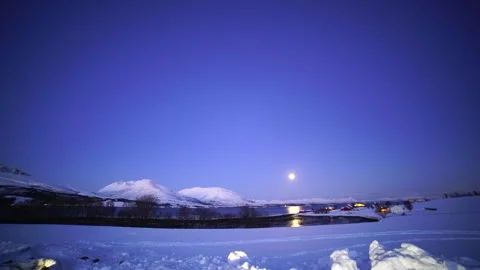 Fjord surrounded by mountains and the full moon rising on the horizon Stock Footage 287928029