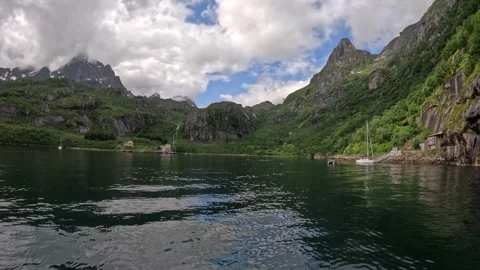 Fjord water reflecting overcast cloudscape and mountain peaks in Lofoten Stock Footage 344753211