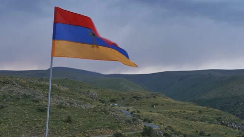 The flag of armenia with a golden cross develops in the wind among the mountains 動画素材 200871813