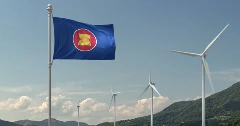 The flag of ASEAN flies gracefully over a blue sky with a row of wind turbines 動画素材 241837982