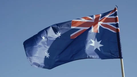 The flag of Australia, develops against the blue sky. Video stock 250669564