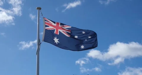 Flag of Australia waving in the wind against blue sky on a sunny day. Vídeo Stock 247318583