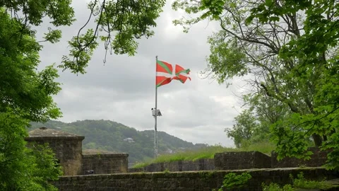 Flag of the Basque Country waving at the top of Mount Urgull next to the city of Stock Footage 312702957