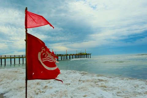 Flag with bathing ban develops in the wind, Atlantic coast beach Stock Photos