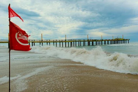 Flag with bathing ban develops in the wind, Atlantic coast beach Stock Photos