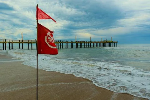 Flag with bathing ban develops in the wind, Atlantic coast beach Stock Photos