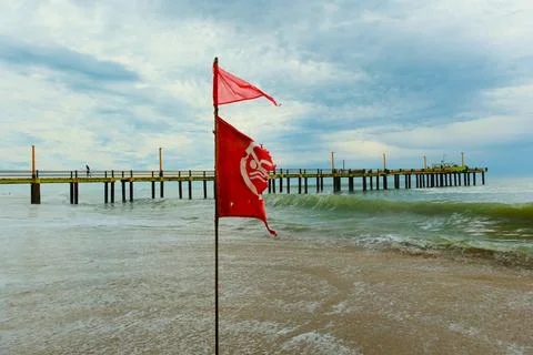 Flag with bathing ban develops in the wind, Atlantic coast beach Foto stock