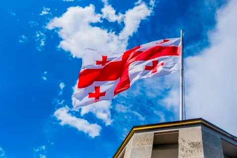 Flag blowing in wind on top of building Fotos de archivo